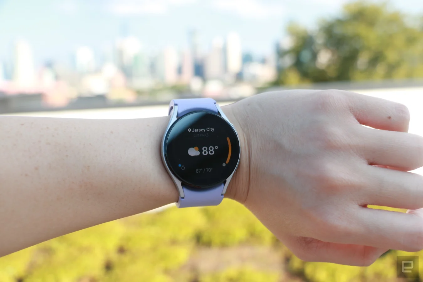 Die Samsung Galaxy Watch 5 am Handgelenk zeigt die Wetter-App.  Oben steht Jersey City, gefolgt von 88 Grad in größerer Schrift, die den größten Teil der Seite einnehmen, und einer Wolke mit Sonnensymbol auf der linken Seite.