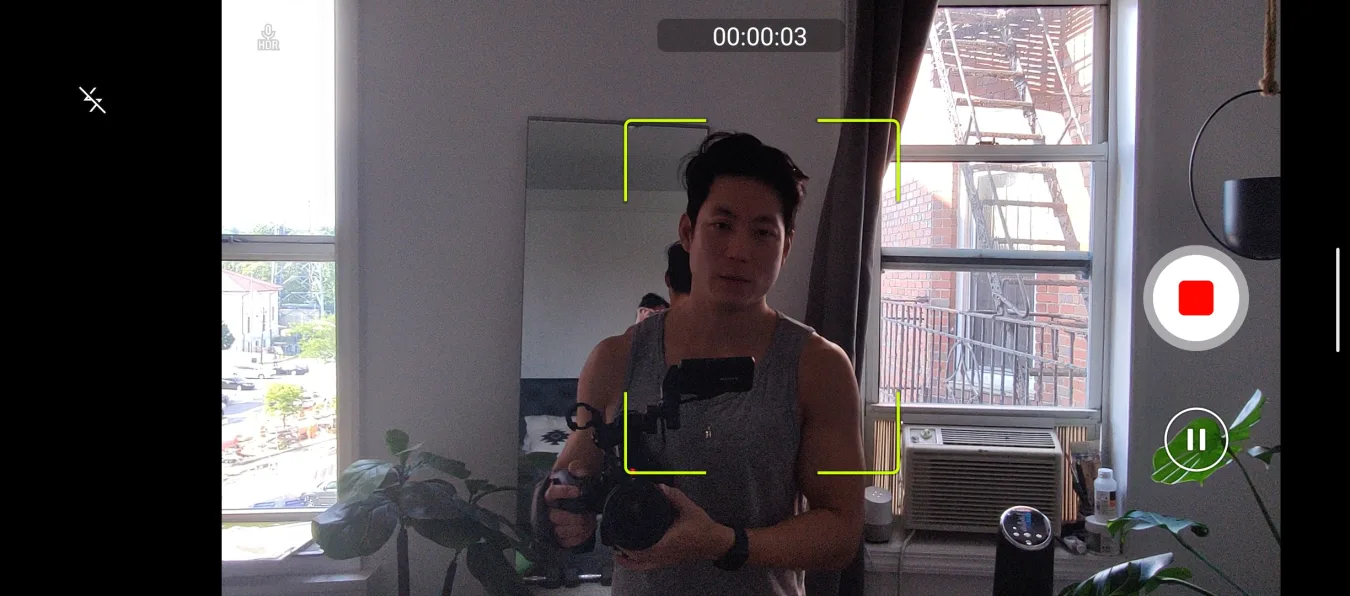 A screenshot of the camera app in the Smartphone for Snapdragon Insiders, demonstrating an Auto Tracking video recording mode. There is a yellow square surrounding a man and Stop and Pause buttons on the right..