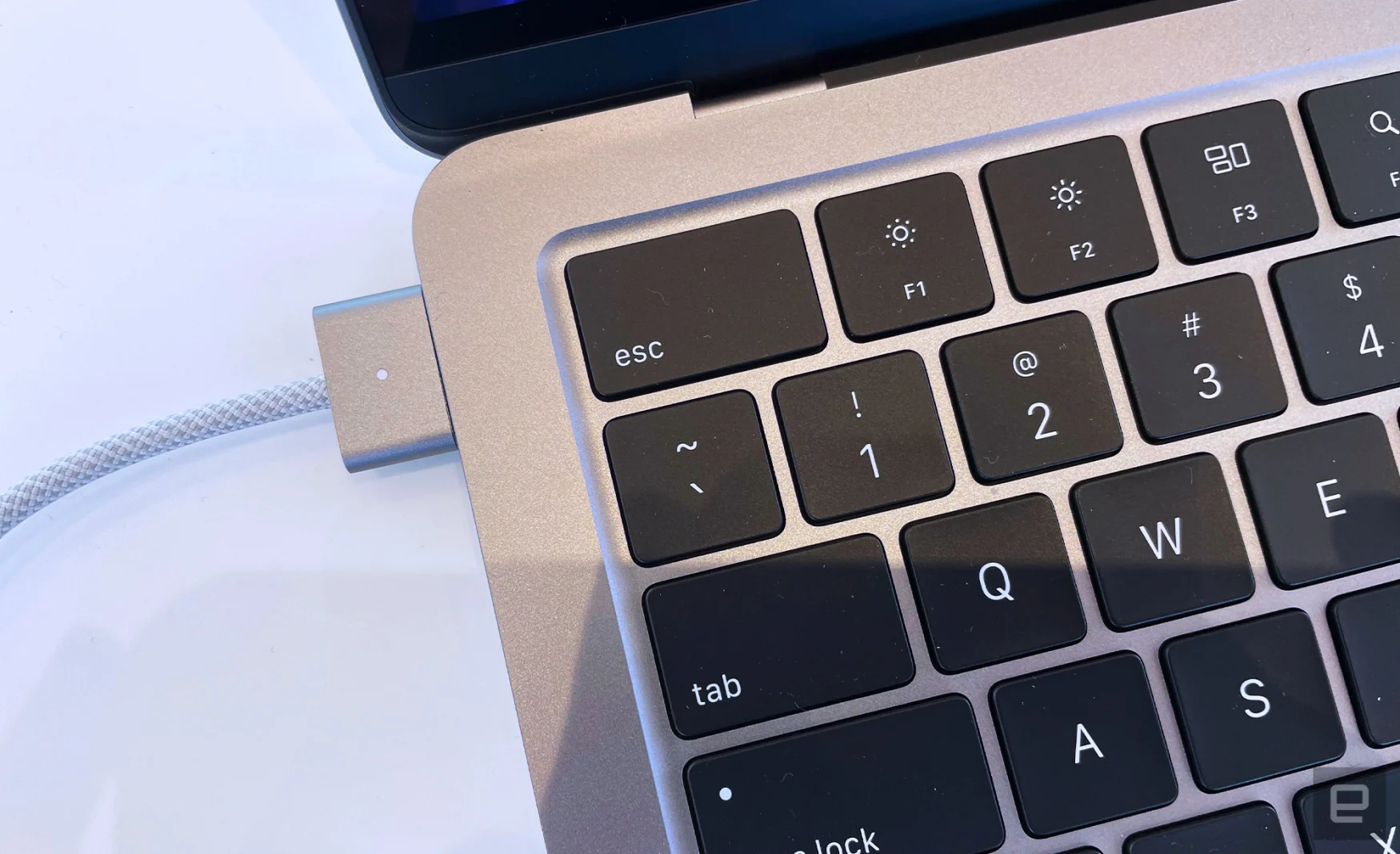 A close-up shot of a MagSafe charger plugged into the new MacBook Air with M2. 