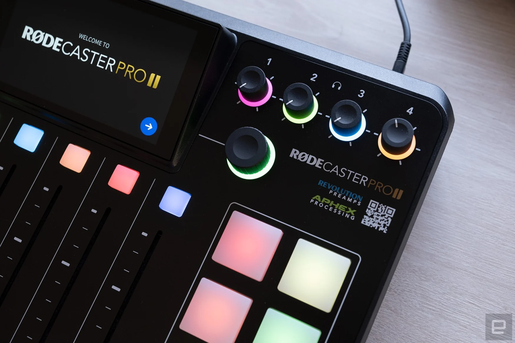 A close up of the top right corner of the Rodecaster Pro II where the headphone volume controls are shown with colored LEDs.