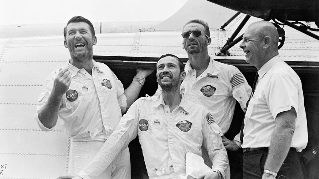 Four astronauts laughing and looking to the horizon in a 196
