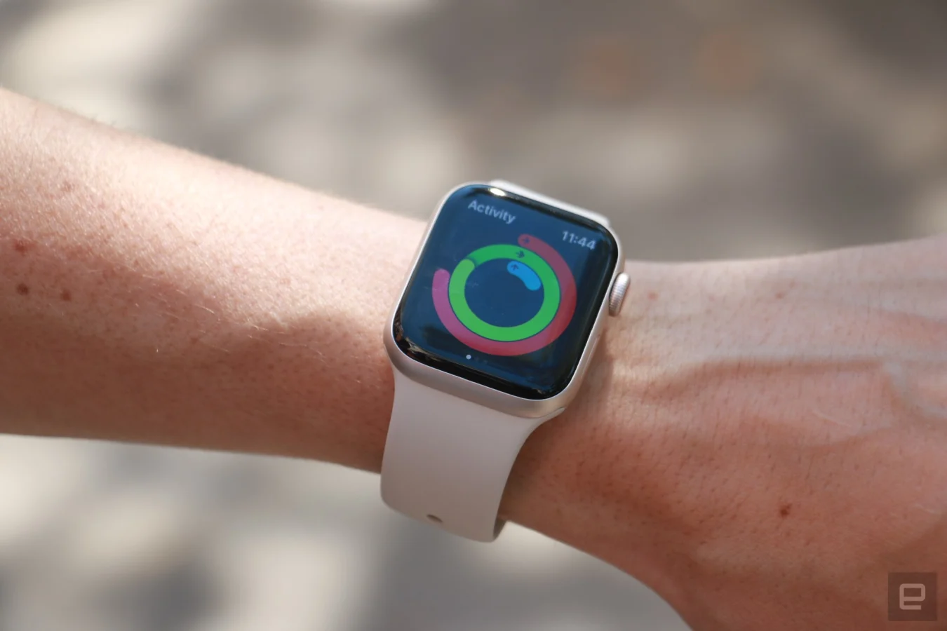 사람의 손목에 장착된 Apple Watch SE (2022). 활동 앱과 반지가 표시됩니다.
