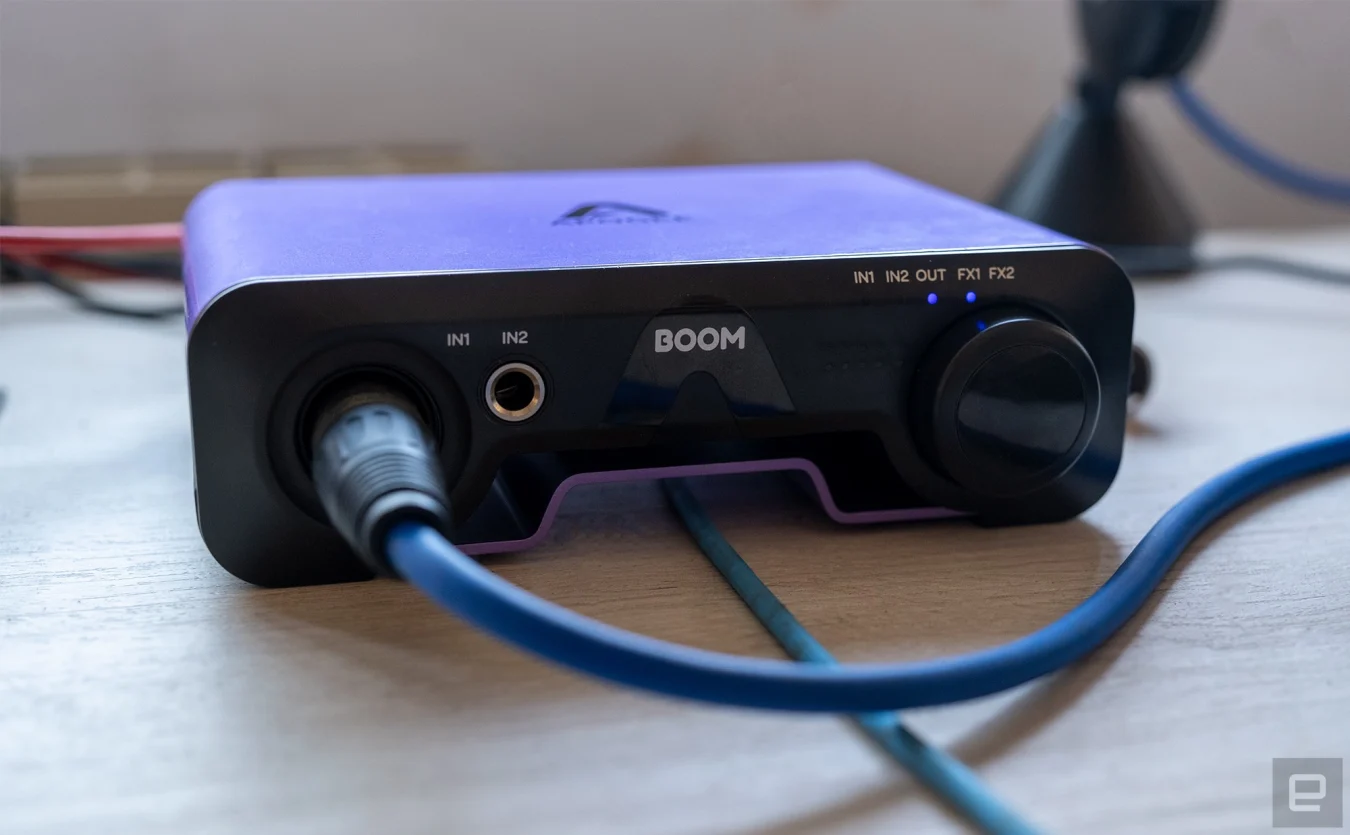 The new Apogee Boom audio interface is shown with the headphone cable running through the gap in the base.