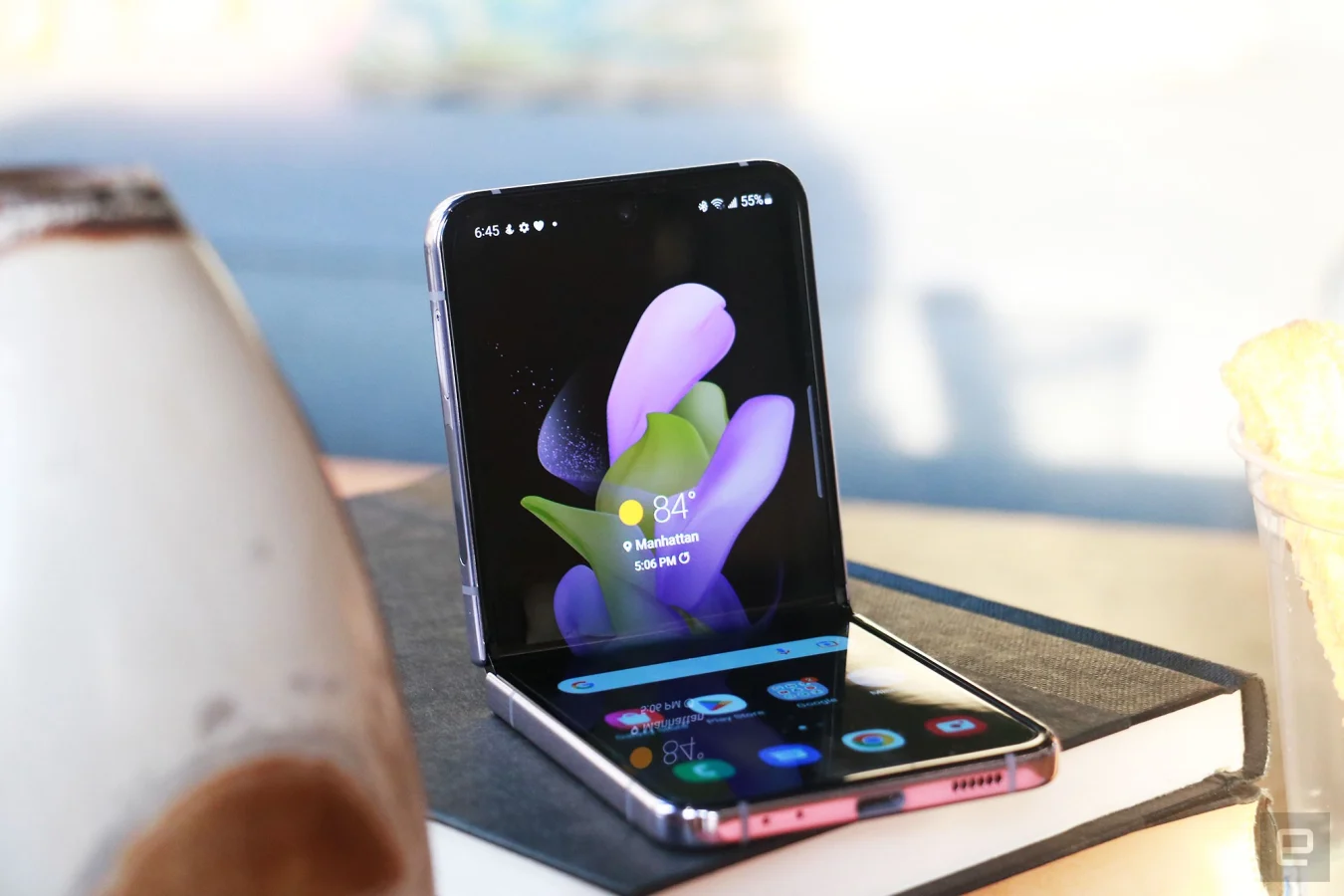 Das Galaxy Z Flip 4 halb gefaltet und auf zwei Bücher gestützt, wobei der Innenbildschirm nach außen zeigt.