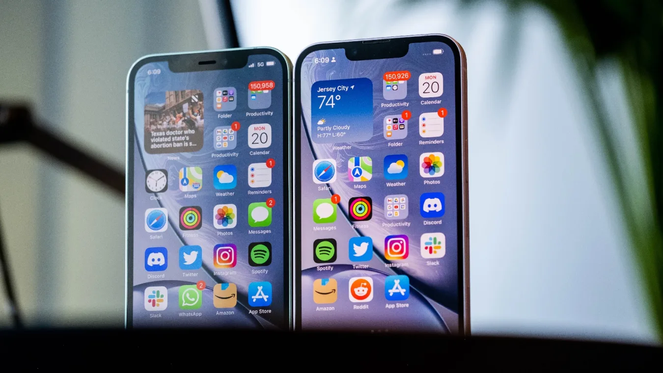 An iPhone 12 and iPhone 13 next to each other with their screens facing the camera.