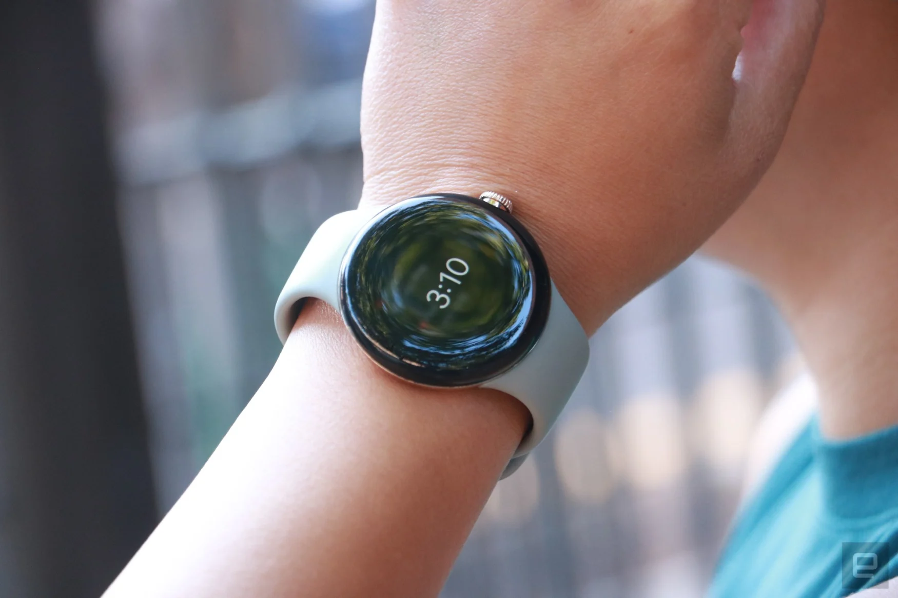 The Pixel Watch on a person's wrist, showing the time as an Always On Display.
