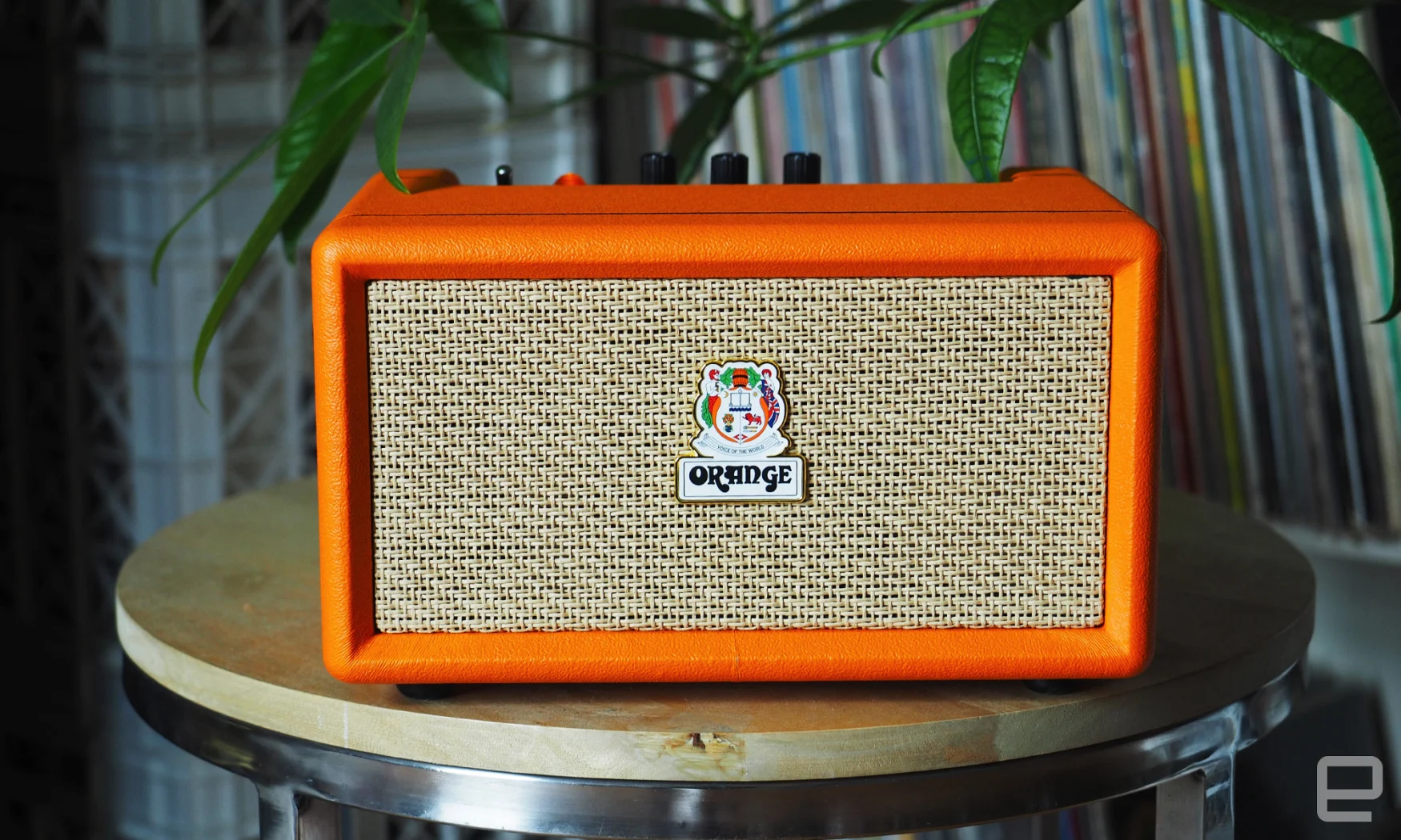 The Orange Amps - Orange Box Bluetooth speaker seen indoors on a round table with a green plant behind it.