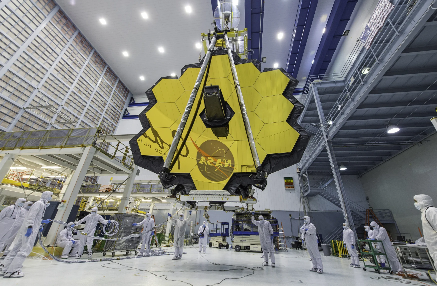 FILE - In this April 13, 2017 file photo provided by NASA, technicians lift the mirror of the James Webb Space Telescope using a crane at the Goddard Space Flight Center in Greenbelt, Md. The telescope's 18-segmented gold mirror is specially designed to capture infrared light from the first galaxies that formed in the early universe. (Laura Betz/NASA via AP, File)
