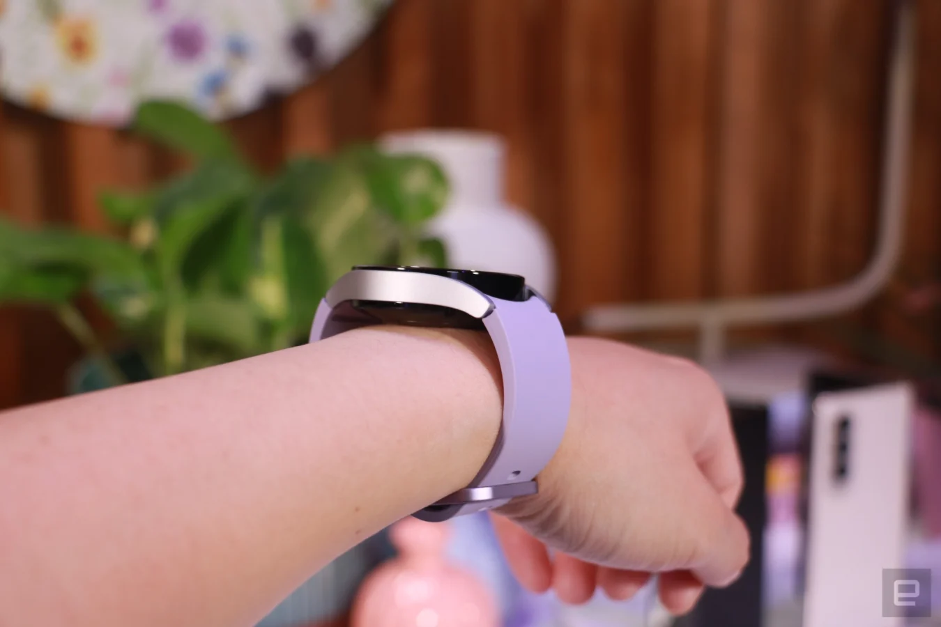 Side view of a purple Galaxy Watch 5 on a wrist, showing its profile and redesigned underside.