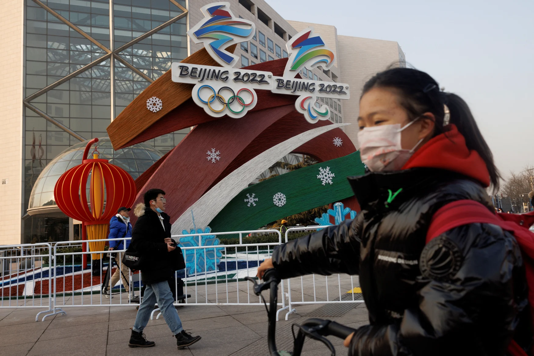 People walk past a display of the logos of the Beijing 2022 Winter Olympics and Paralympics in Beijing, China, January 14, 2022. REUTERS/Thomas Peter