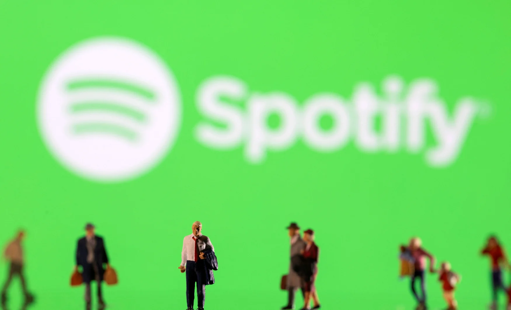 Small figurines are seen in front of displayed Spotify logo in this illustration taken February 11, 2022. REUTERS/Dado Ruvic/Ilustration