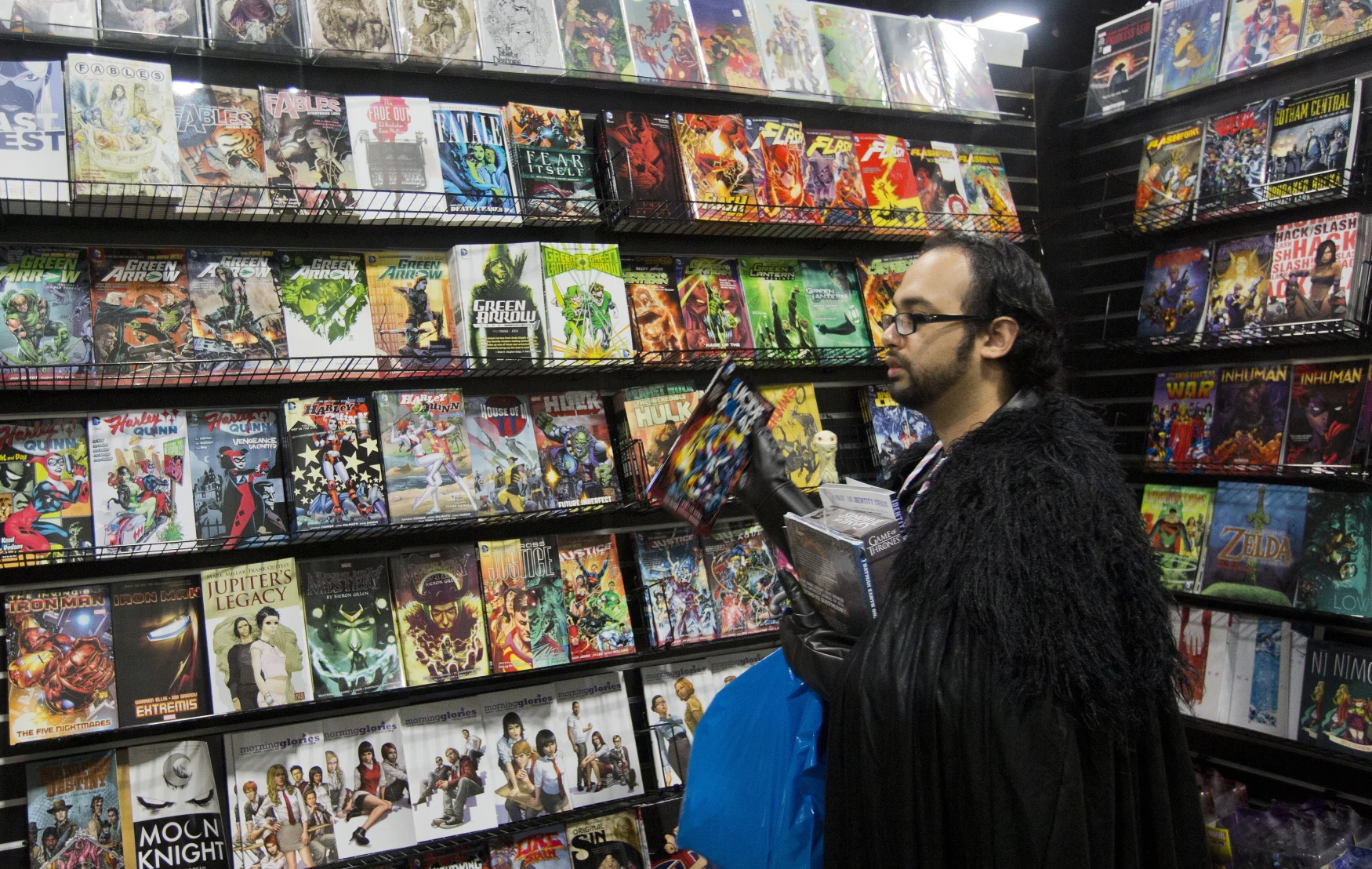 A convention attendee buys comic books at the DC Awesomecon comic book convention in Washington, DC, on May 29, 2015. AFP PHOTO/ ANDREW CABALLERO-REYNOLDS        (Photo credit should read Andrew Caballero-Reynolds/AFP via Getty Images)