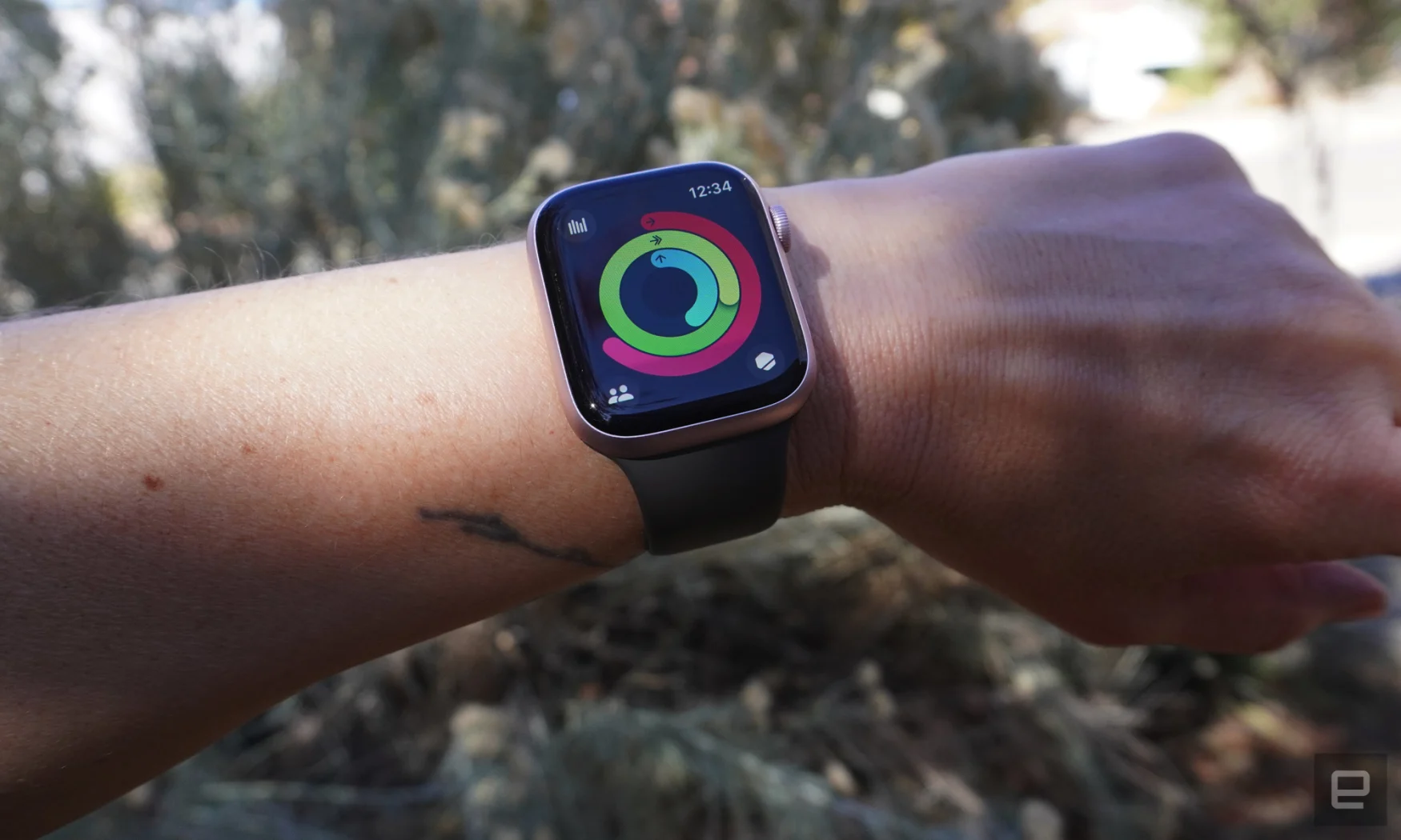 A person wears the Apple Watch that's displaying the Activity App and the fitness rings.  