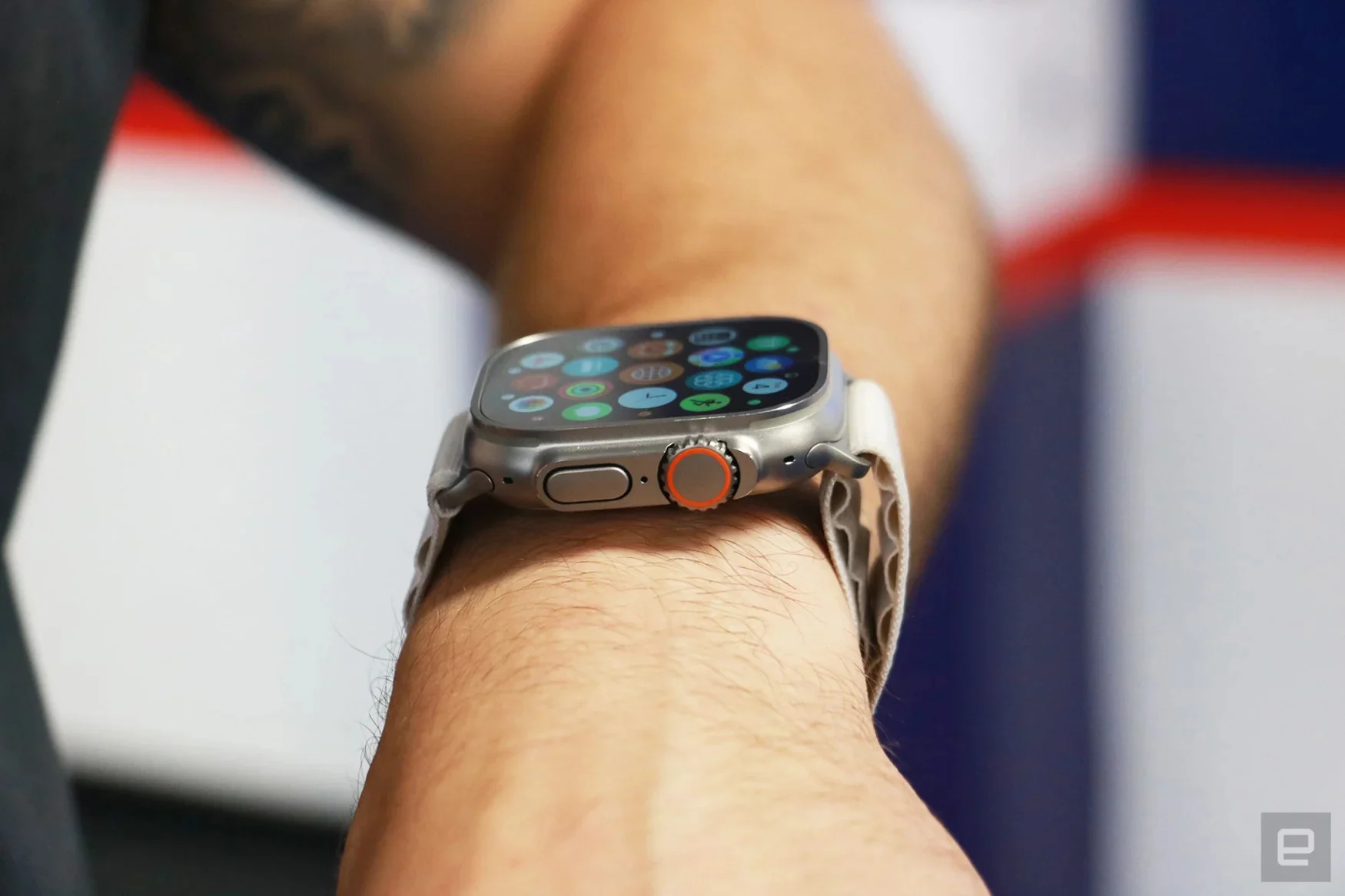 Photo of a person wearing the Apple Watch Ultra. Side view taken from the person's right side (they're wearing the watch on their left wrist).