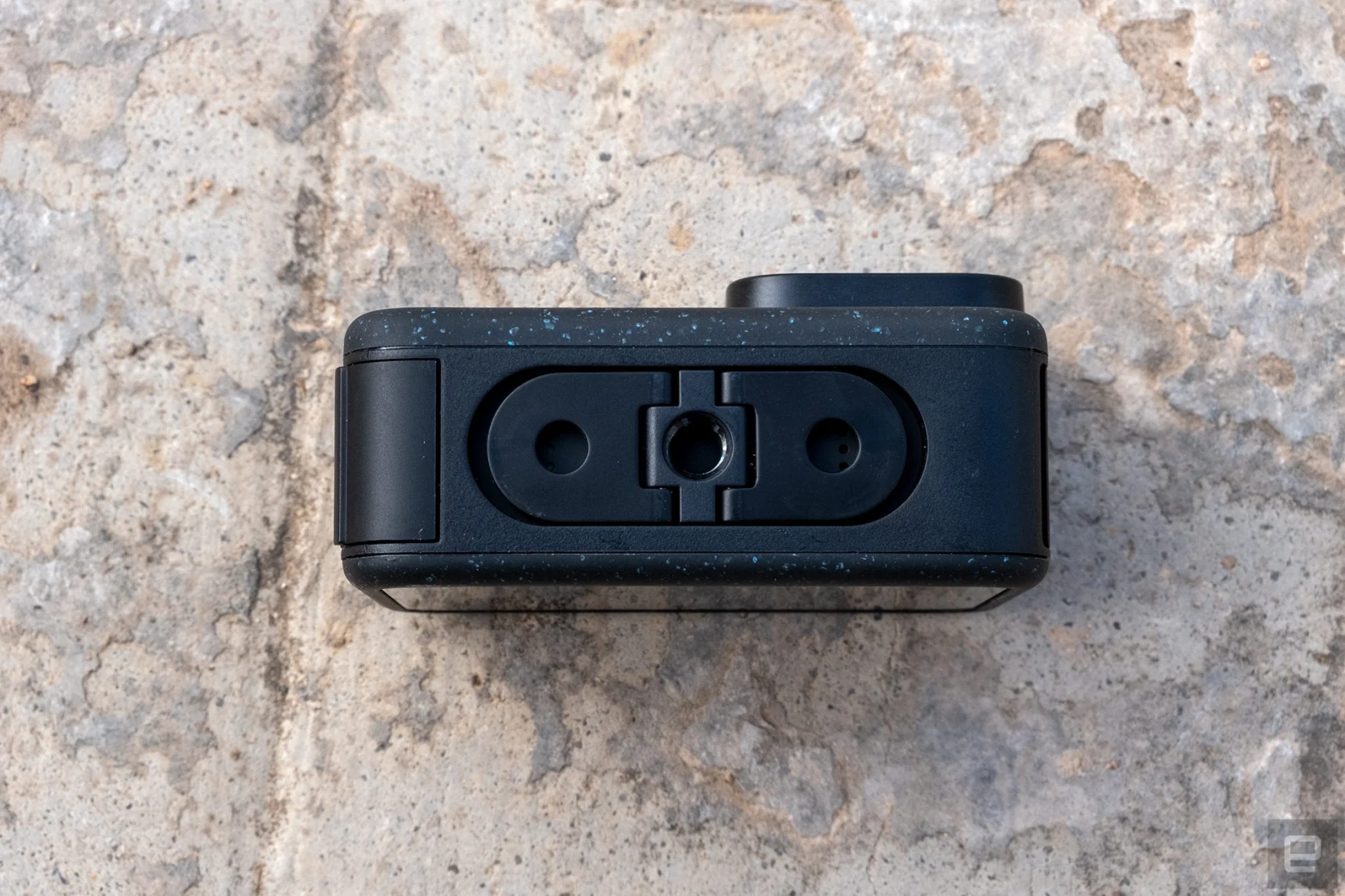 The underside of the GoPro Hero 12 Black is shown revealing the new standard tripod mount.