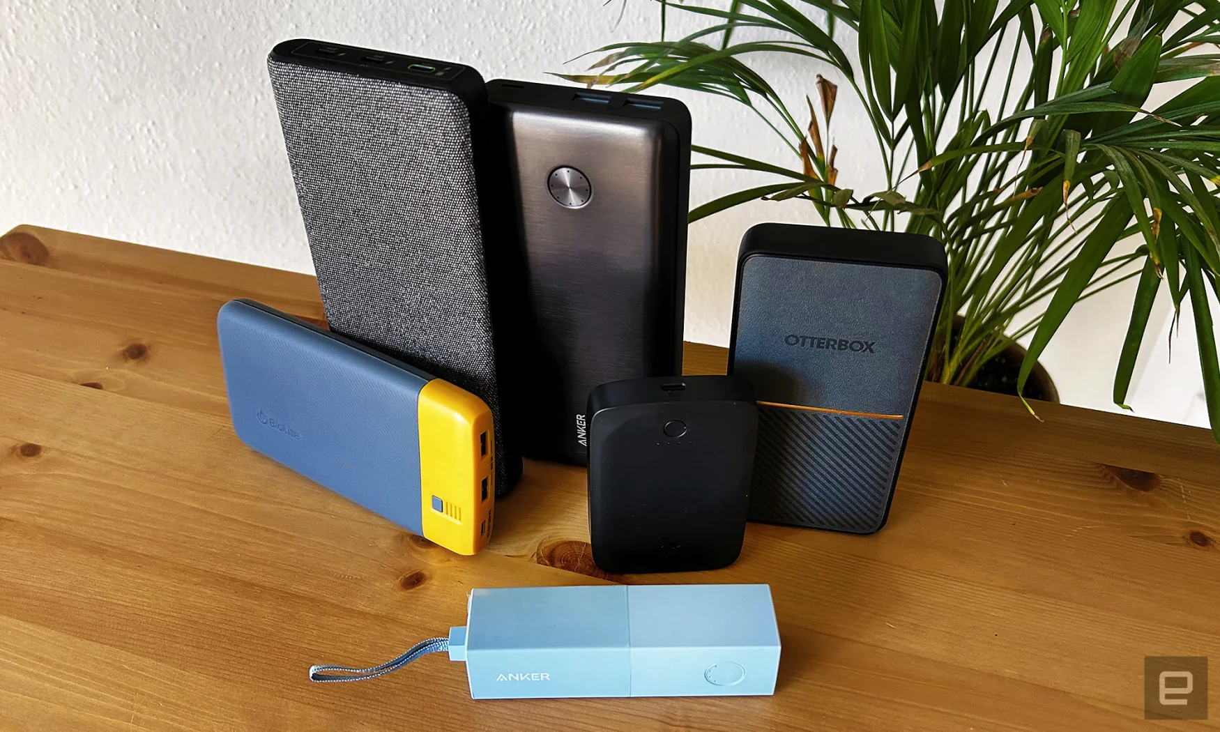 The six winning power banks arranged on a wooden table with a houseplant in the background 