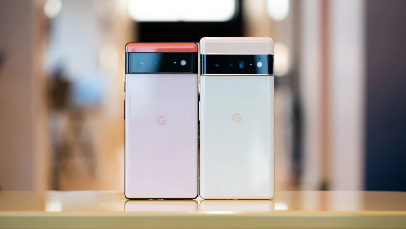 The Google Pixel 6 and 6 Pro on a table with their rear cameras facing out.