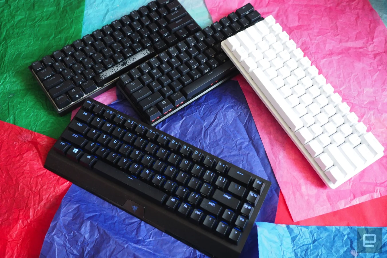 Keyboards at 60 percent on a bed of colored paper