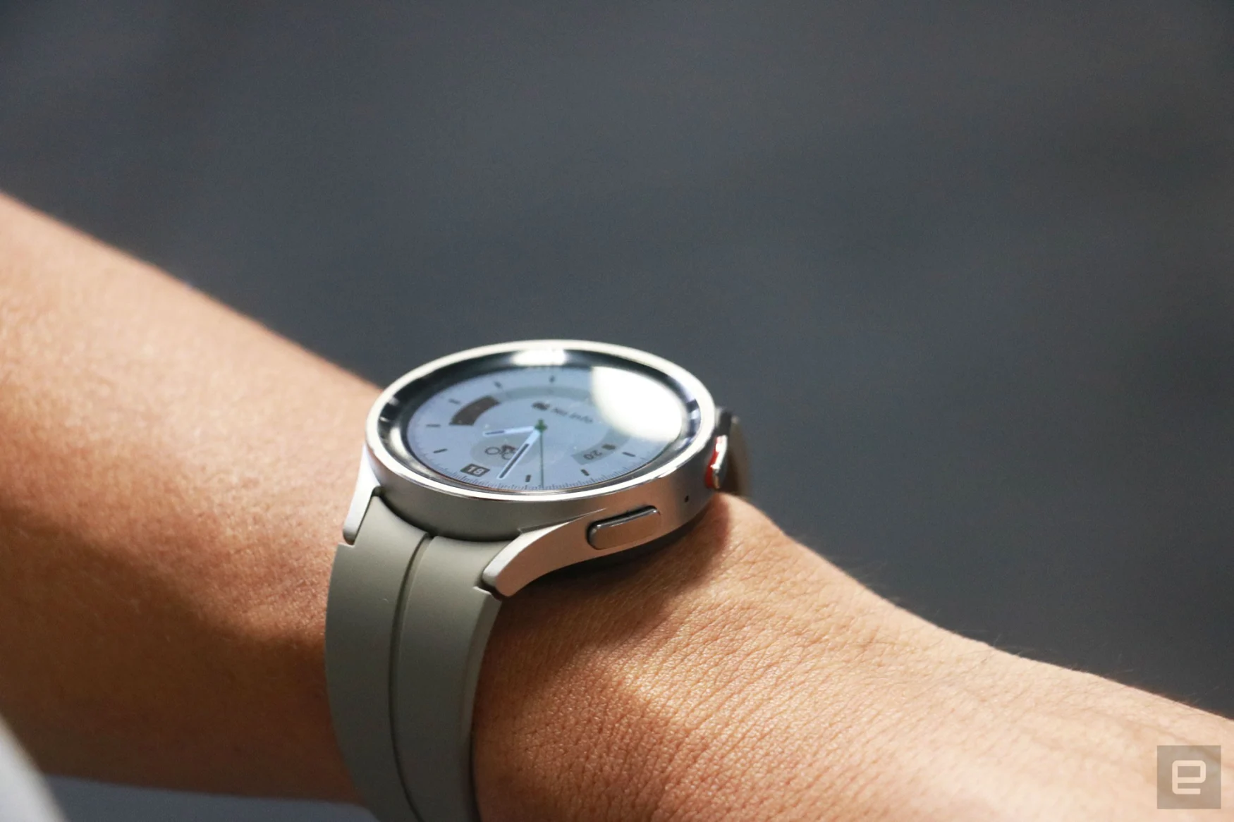 The Samsung Galaxy Watch 5 Pro on a wrist, with some lights reflecting off its screen.