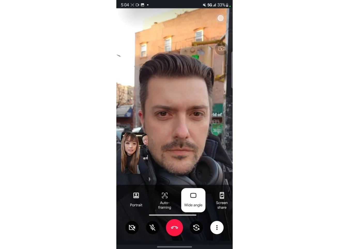 A screenshot of a Google Duo video call on the Galaxy S22 Ultra. A man's face fills the screen, while a woman's face is in a small box to the bottom left. Below their faces is a row of options including 