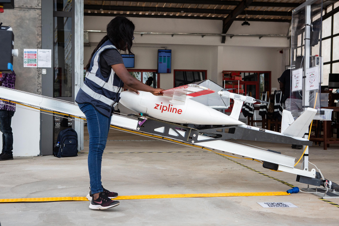A staff member prepares a drone for the delivery of medical supplies at the drone delivery service base run by operator Zipline in Omenako, 70 kilometres (40 miles) north of Accra on April 23, 2019. - Ghana launched a fleet of drones on April 24, 2019 to carry medical supplies to remote areas, with Ghana's President declaring it would become the "world's largest drone delivery service." The craft are part of an ambitious plan to leapfrog problems of medical access in a country with poor roads. The drones have been flying test runs with blood and vaccines, but the project was officially inaugurated Wednesday at the main drone base in Omenako, 70 kilometres (40 miles) north of Accra. Operator Zipline, a US-based company, said the three other sites should be up and running by the end of 2019. The drones are planned to ferry 150 different medicines, blood, and vaccines to more than 2,000 clinics serving over 12 million people -- roughly 40 percent of the population. (Photo by Ruth McDowall / AFP)        (Photo credit should read RUTH MCDOWALL/AFP via Getty Images)