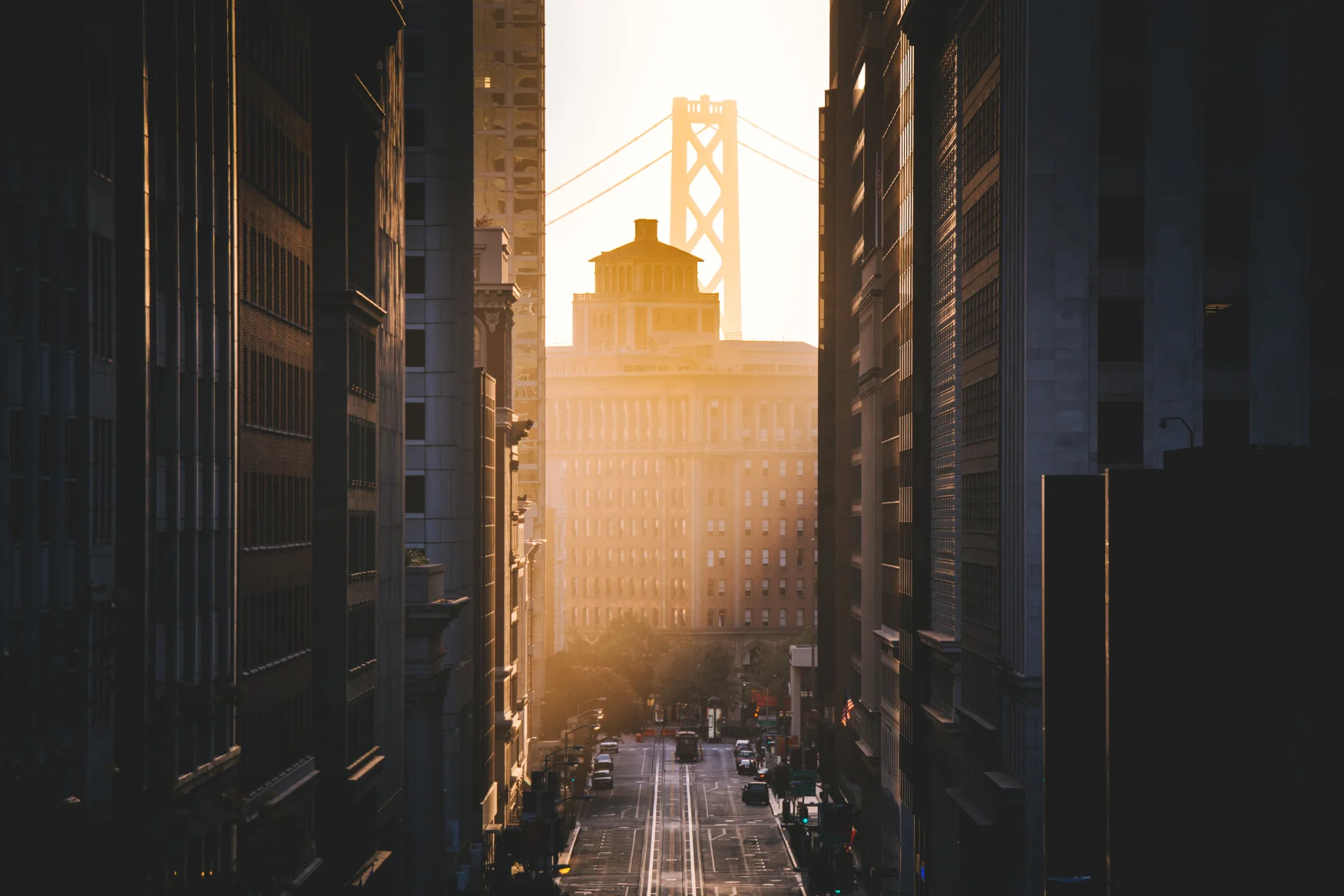 Classic view of historic California Street with famous Oakland Bay Bridge illuminated in first golden morning light at sunrise in summer, San Francisco, California, USA