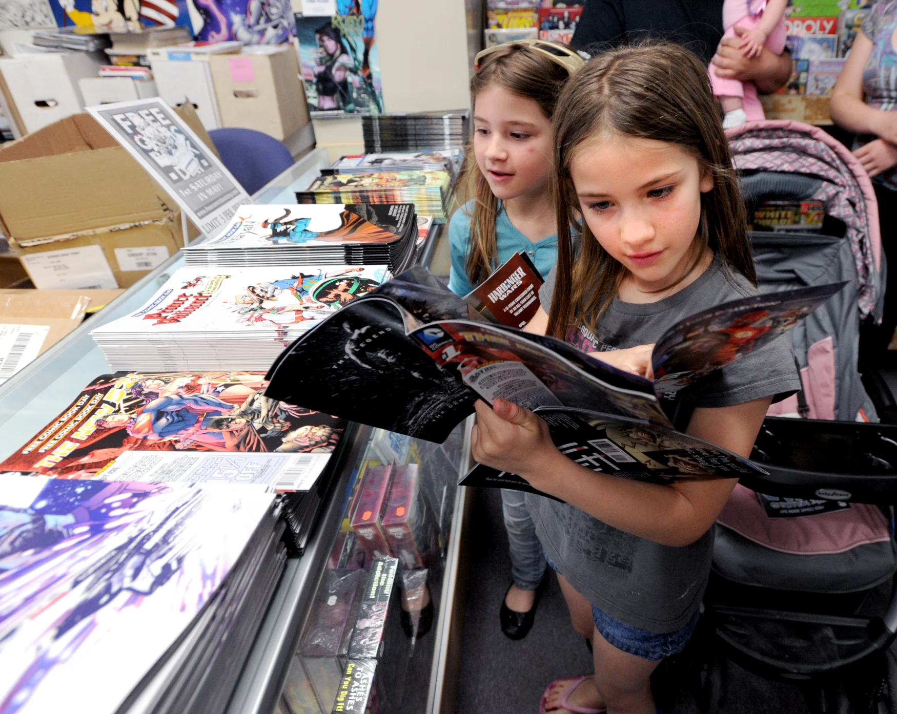 Nikki Beck, 9, right, and her sister, Alana, 8, both of Firestone, look through the free comics in order to make their choice.Time Warp Comics in Boulder is one of thousands of comic book shops around the world celebrating Free Comic Book Day on May 4th. On Free Comic Book Day, over 3.3 million comic books will be given away by participating stores.(Photo by Cliff Grassmick/Digital First Media/Boulder Daily Camera via Getty Images)