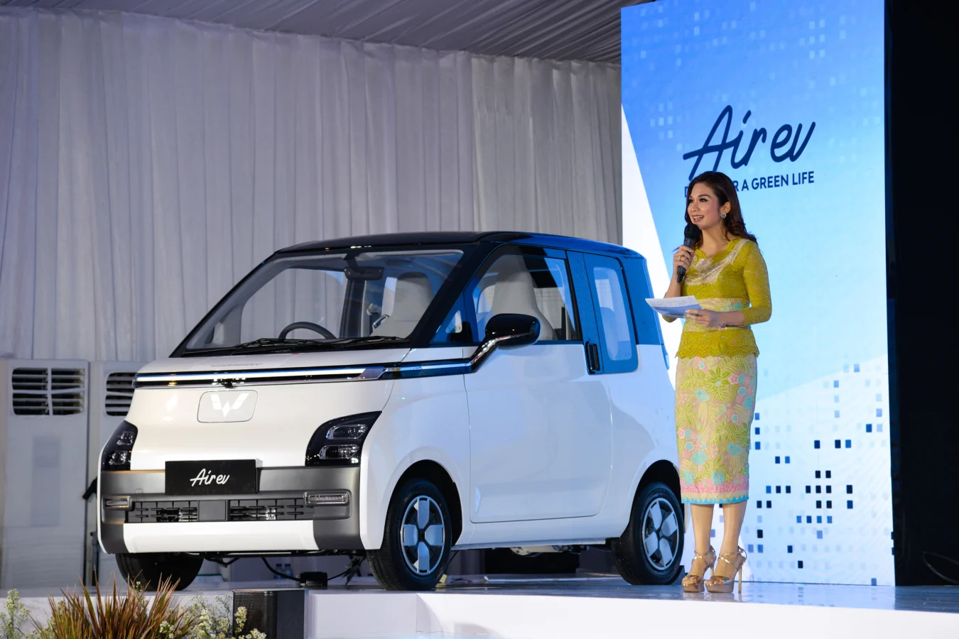 A hostess briefs people on Wuling Air EV during the roll-out ceremony at Wuling's production factory in Bekasi, West Java province, Indonesia, Aug. 8, 2022. SAIC-GM-Wuling SGMW, a major Chinese automobile manufacturer, through its local unit SGMW Motor Indonesia Wuling, on Monday launched here its production of the electric vehicle in Indonesia, named Wuling Air EV. (Photo by Xu Qin/Xinhua via Getty Images)