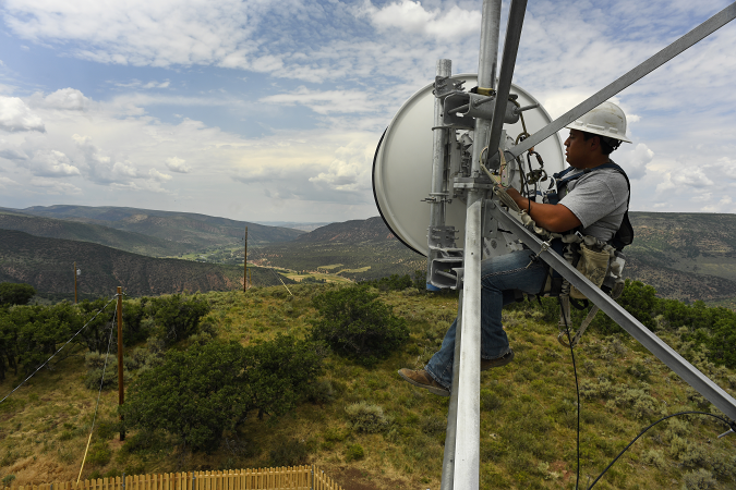 MEEKER, CO - AUGUST: Jackson Federico, a tower technician for Advanced Wireless Solutions, works to make some repairs on the dish on the Pollard cell tower high off the ground in rural Rio Blanco County  on July 12, 2017 near Meeker, Colorado.  Broadband in Rio Blanco county and Meeker is some of the best in the state for rural areas. (Photo by Helen H. Richardson/MediaNews Group/The Denver Post via Getty Images)