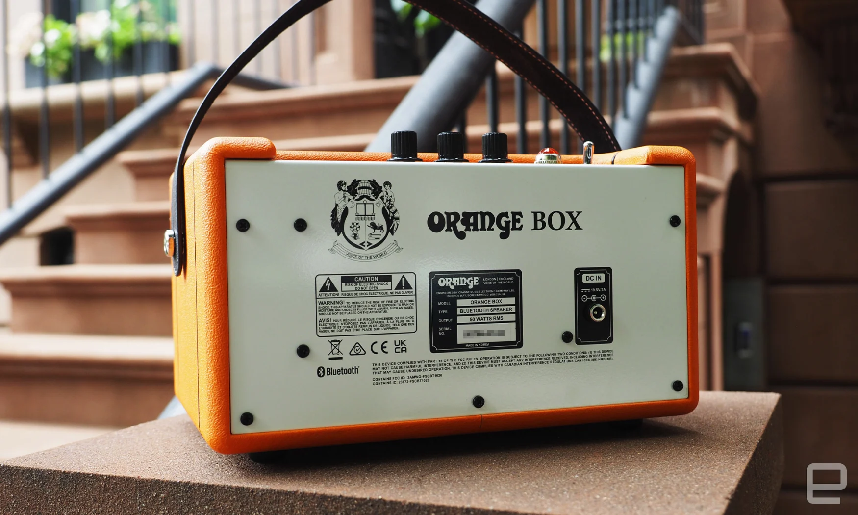 The Orange Amps - Orange Box Bluetooth speaker seen on the stoop of a brownstone, showing the rear panel.