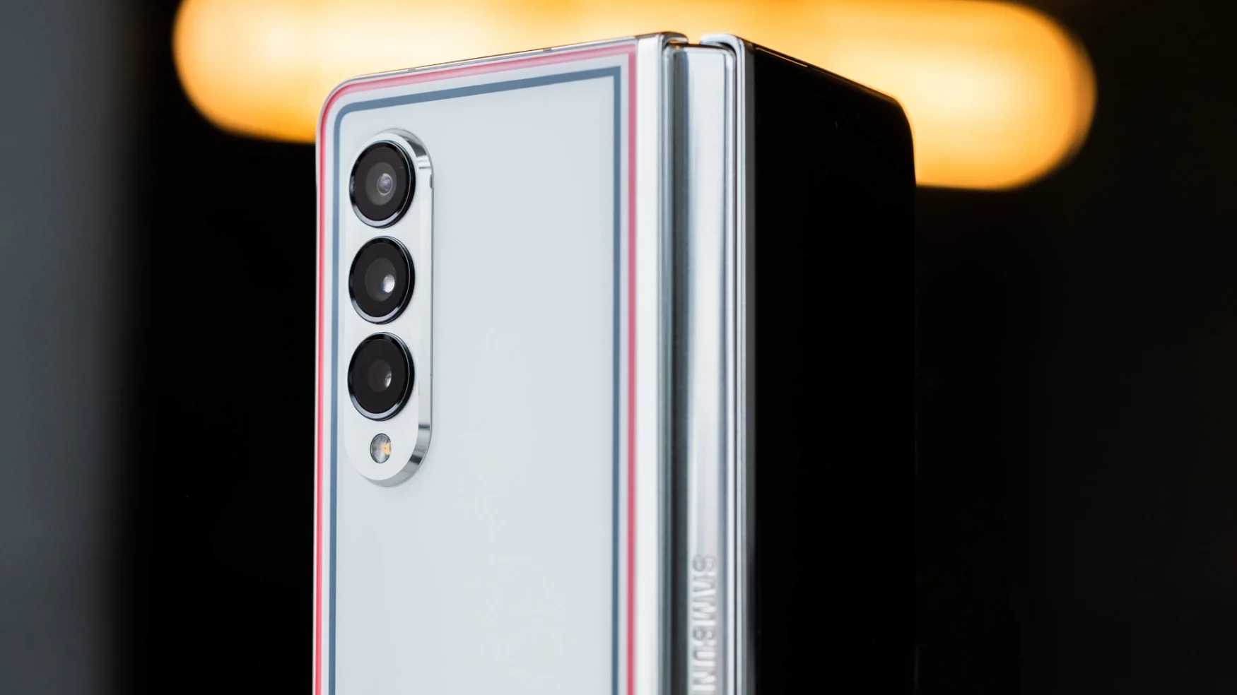 The Thom Browne edition of the Samsung Galaxy Z Fold half opened and with its back facing the camera.