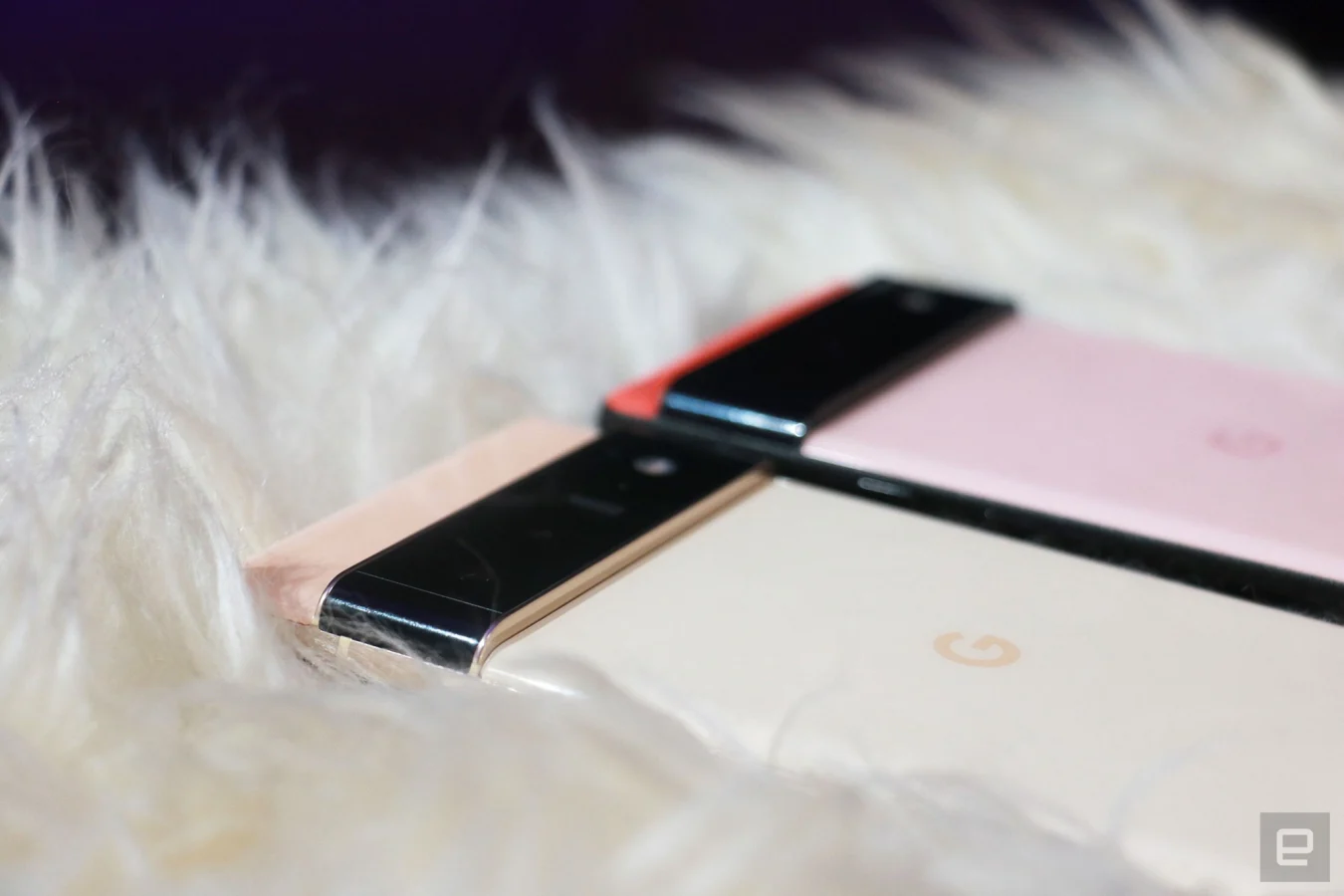 Close ups of the Pixel 6 and Pixel 6 Pro camera bumps as the phones are laid out on a furry surface.