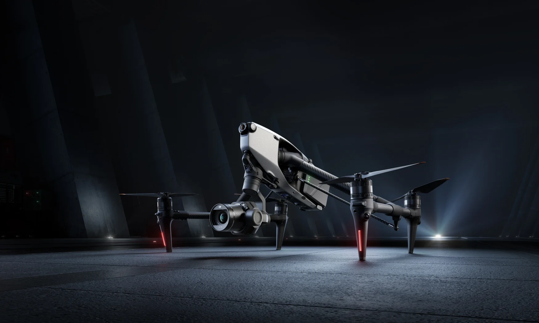 Marketing photo of the DJI Inspire 3 drone, sitting in dramatic lighting on a gray surface.