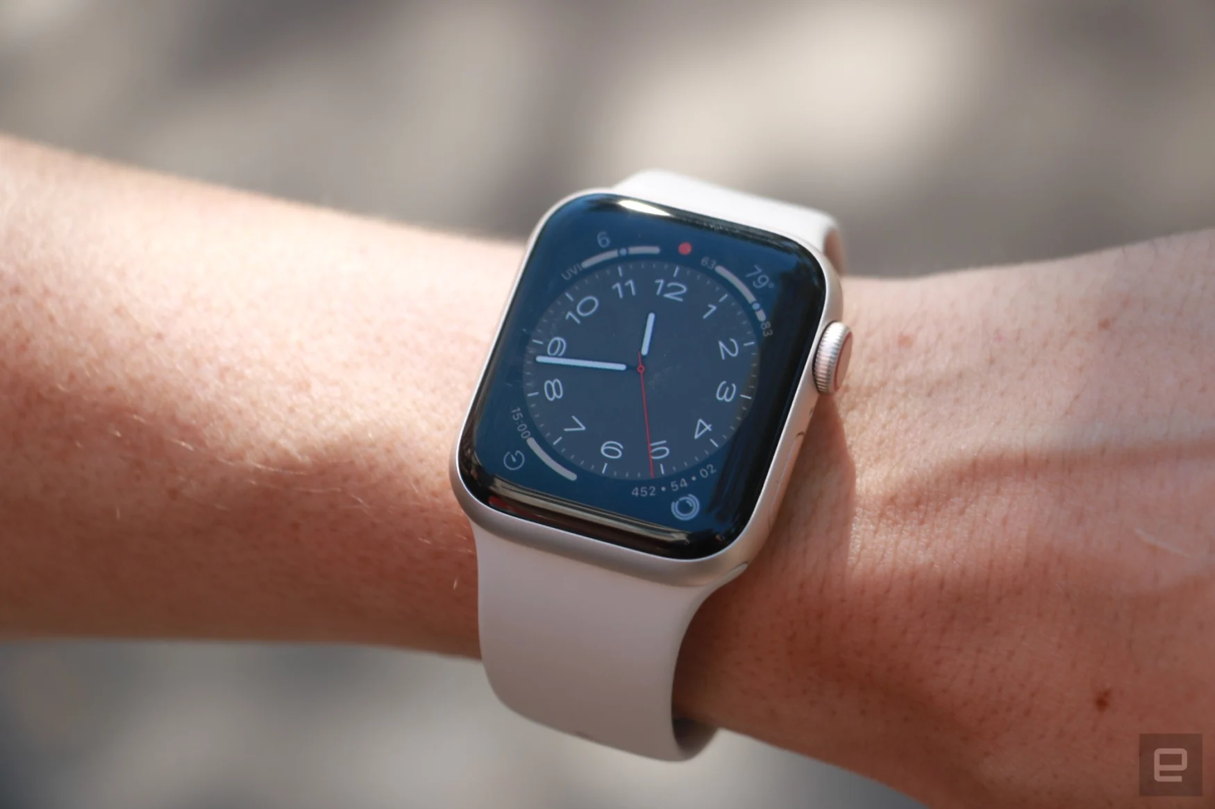 L'Apple Watch SE (2022) avec un boîtier Starlight et un bracelet Starlight, au poignet d'une personne.