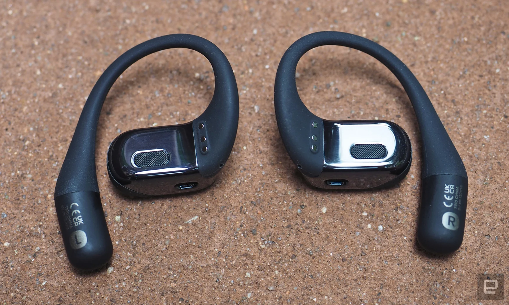 Close-up images of the Shokz OpenFit open-ear buds in grey. 