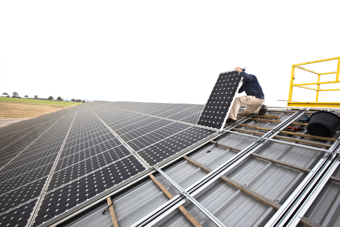 Setting up of solar panels on the roof of a farm shed, used to produce electricity. (Photo by: Andia/Universal Images Group via Getty Images)