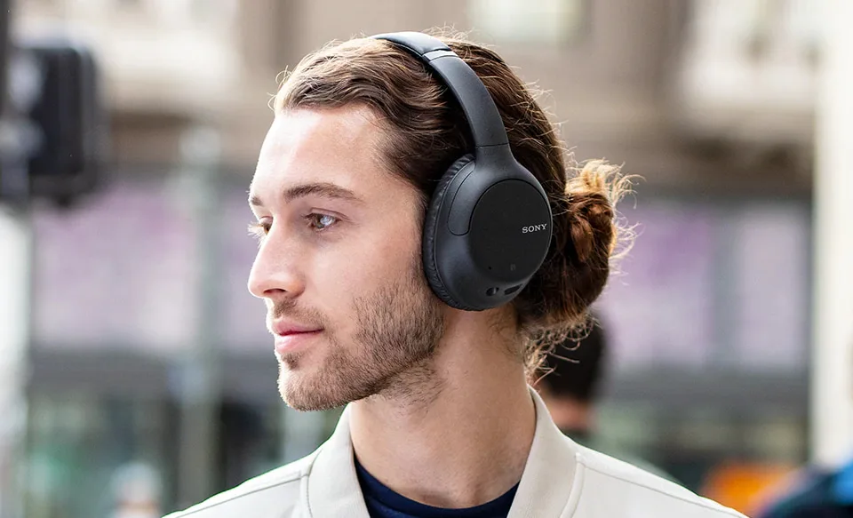 A person wears Sony's WH-CH710N headphones.