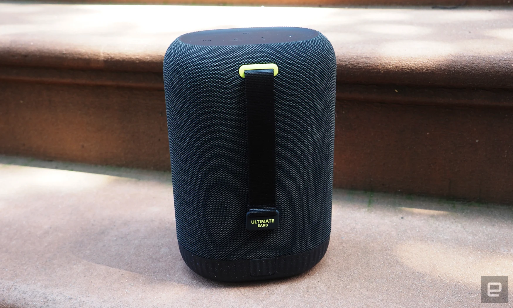 The UE Epicboom shows off its backside and carry strap while resting on the steps of a stoop.