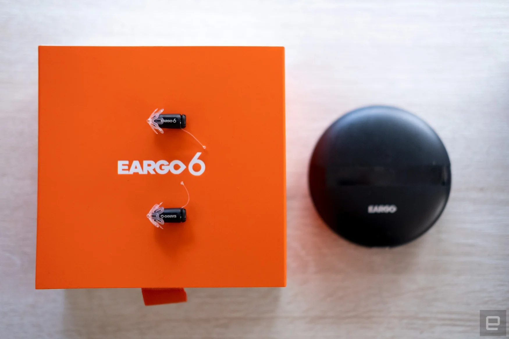Eargo 6 hearing aids with Sound Adjust shown on their packaging with the portable charger.