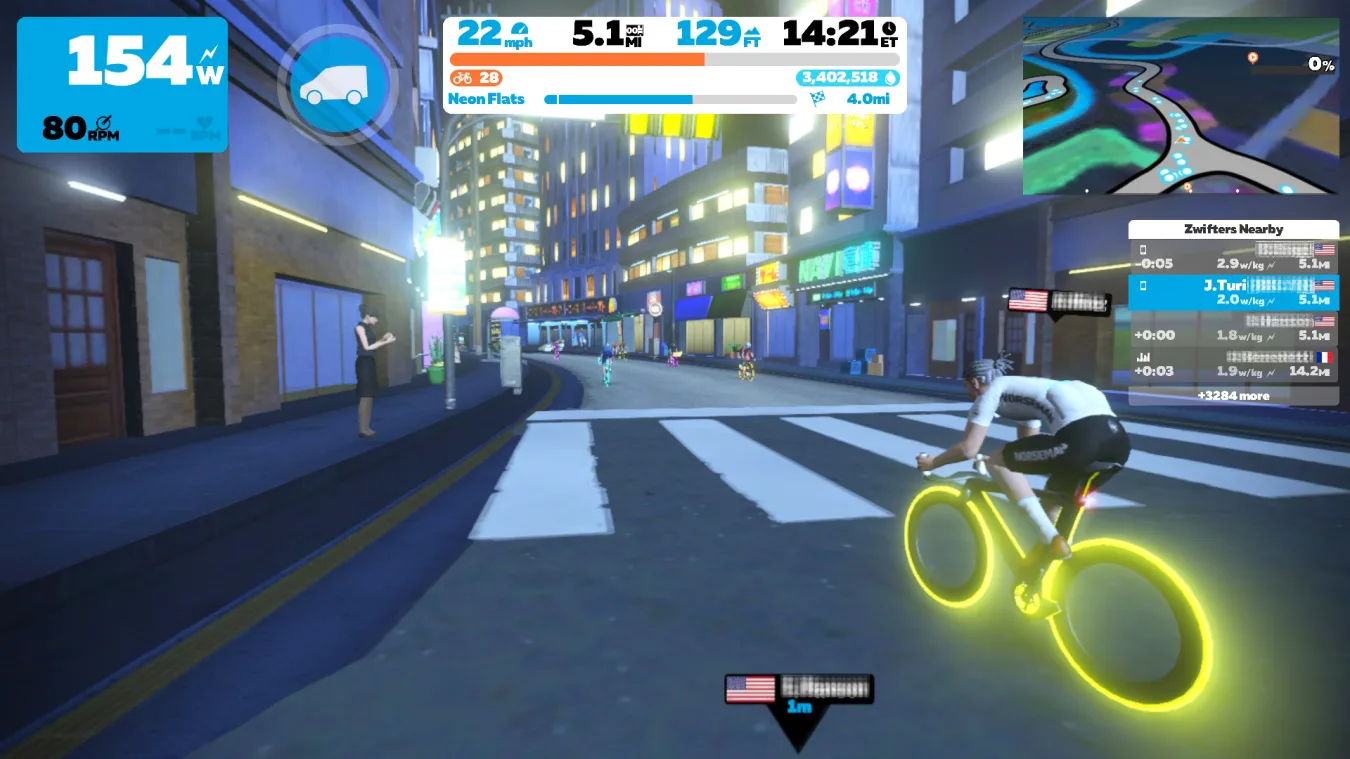 A screenshot from the cycling sim Zwift showing the Neokyo city environment.