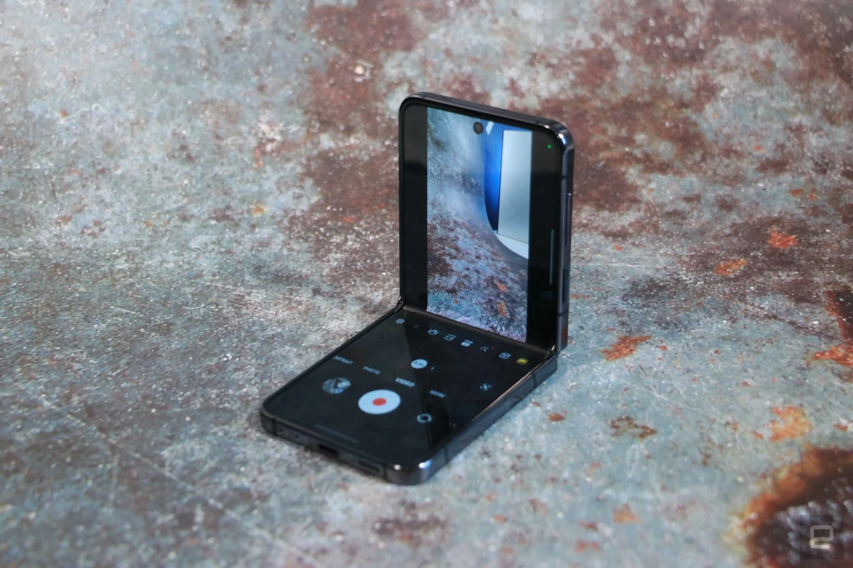 The Samsung Galaxy Z Flip 5 flexed at a 90-degree angle, with its internal display showing the camera app.