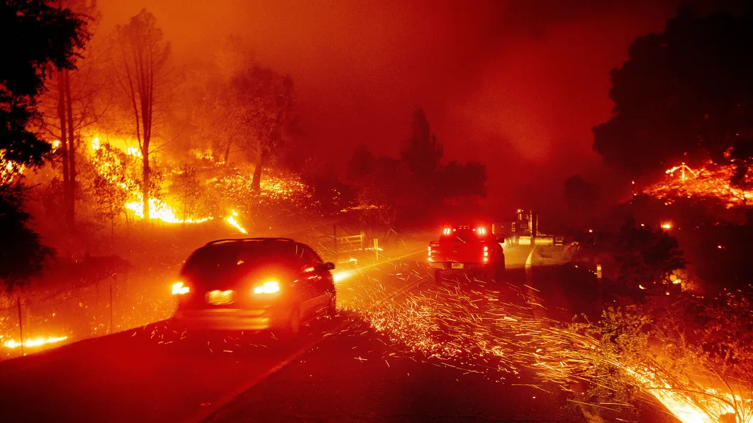 Embers fly across a roadway as the Kincade Fire burns through the Jimtown community of Sonoma County, Calif., Oct. 24, 2019. (AP Photo/Noah Berger)